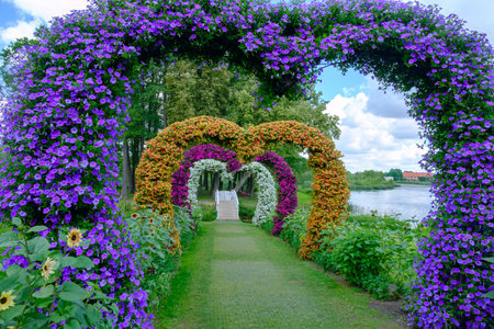 Pakruojis, Lithuania - July 7, 2023: Pakruojis manor flower installation in the shape of a heart. Multicolored petunia flowers Baltic States, Europe.のeditorial素材