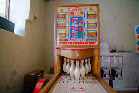Pakruojis, Lithuania. July 7, 2023: Retro board games. slot machine. Mini bowling game. An old-timey entertainment device in a dark roomのeditorial素材