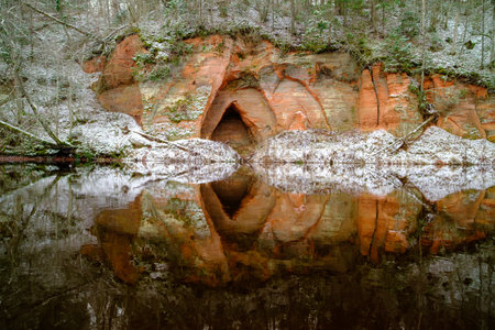 View to the Angels cave, a red sandstone cliff at the river Salaca in Skanaiskalns Nature Park in Mazsalaca in November in Latvia.の写真素材