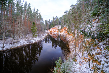 The river Salaca is meandered by high sandstone cliffs. Skanaiskalns nature park. November is the first snow in Mazsalaca in Latvia.の写真素材