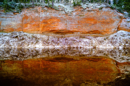 The river Salaca is meandered by high sandstone cliffs. Skanaiskalns nature park. November is the first snow in Mazsalaca in Latvia.の写真素材