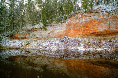 The river Salaca is meandered by high sandstone cliffs. Skanaiskalns nature park. November is the first snow in Mazsalaca in Latvia.の写真素材