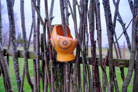 Old pitched pitcher like scenery in the garden. A broken clay mug on the fence.の写真素材