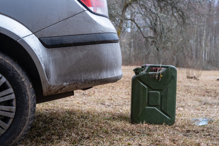 Gas can beside car in field with alloy wheels and treaded tires