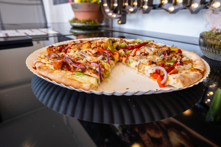 Slice missing from Californiastyle pizza on paper plateの写真素材