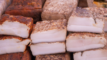 Assorted pieces of traditional salted and smoked pork lard seasoned with garlic, pepper, and...