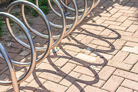 Parking spaces for bicycles and an abstract falling shadow on the road.