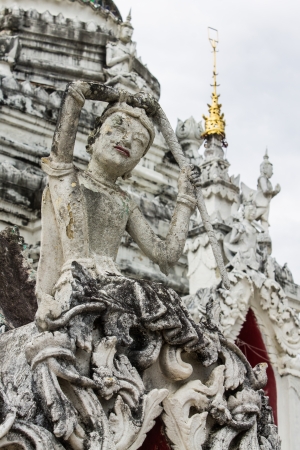 White Phra Mae Thorani Statue With Pagoda in Thailandの写真素材