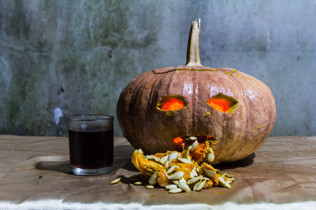 Haunted carved pumpkins for Halloween with liqueurの写真素材