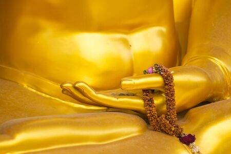 golden hand buddha with old garlandの写真素材