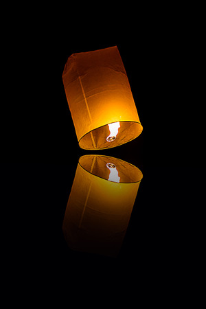 lanna Fly Lantern during the Loi Krathong Festival with  reflection isolated on blackの写真素材