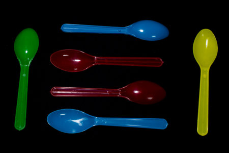 plastic spoon isolated on black backgroundの写真素材