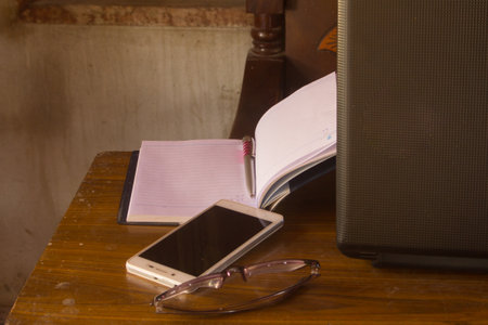 smart phone  and Pen,  book with glass, and notebook on tableの写真素材