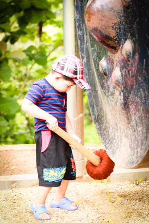Asian Thai children boy plays the big gong in Thai templeの写真素材