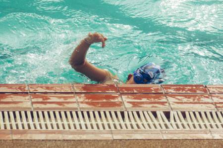 Asian child competing swimmer in the swimming poolの写真素材