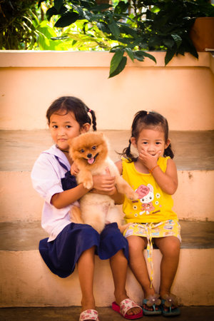 Cute Asian childs with pomeranian dogの写真素材