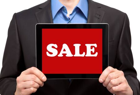 businessman in a suit holding a tablet touch pad computer gadget with the word sale on a red screenの写真素材