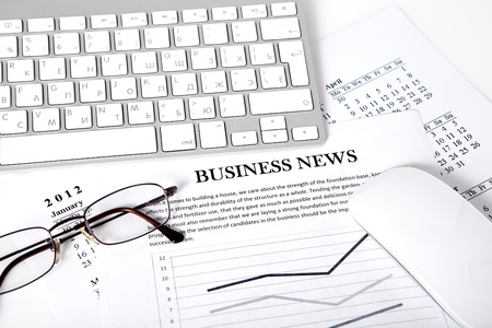 desk with a computer calendar businessman and business plan with the newsの写真素材