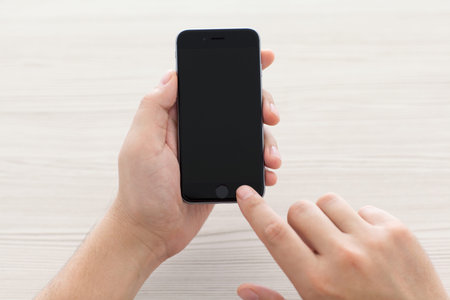 Alushta, Russia - October 23, 2014: Man switch on the new iPhone 6 Space Gray holding it over the...