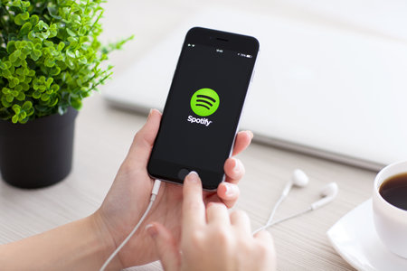 Alushta, Russia - October 24, 2014: Girl holding a iPhone 6 Space Gray with music service Spotify on the screen. iPhone 6 was created and developed by the Apple inc.のeditorial素材