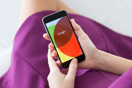 Alushta, Russia - November 22, 2014: Woman holding a iPhone 6 Space Gray with social networking service Google plus on the screen. iPhone 6 was created and developed by the Apple inc.のeditorial素材