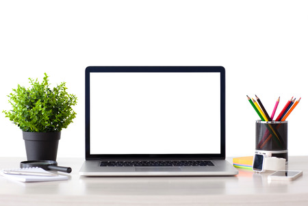 laptop computer with isolated screen stands on the table in the office with phone and watch