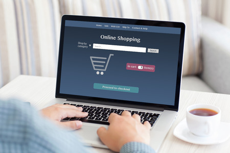 man sitting at a computer and makes online shopping in the roomの写真素材