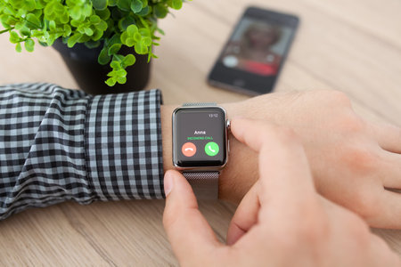 Alushta, Russia - August 11, 2015: Man hand with Apple Watch and phone call on the screen. Apple Watch was created and developed by the Apple inc.のeditorial素材