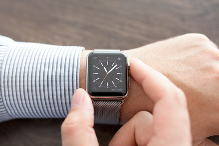 Alushta, Russia - September 1, 2015: Man hand with Apple Watch on the desk. Apple Watch was created and developed by the Apple inc.のeditorial素材