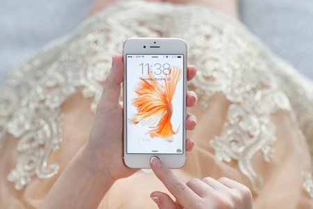 Alushta, Russia - October 22, 2015: Woman unlock iPhone6S Rose Gold with live photo on the display. iPhone 6S was created and developed by the Apple inc.のeditorial素材