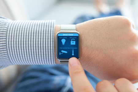 Man hands with watch and smart home on the screenの写真素材