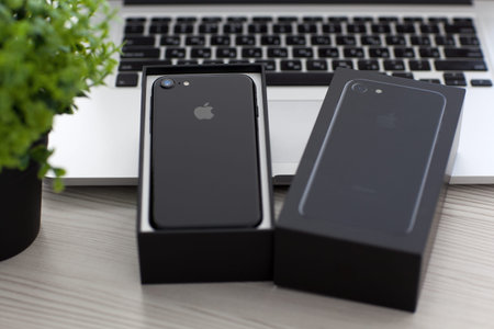 Alushta, Russia - November 2, 2016: Unboxing new iPhone 7 in the MacBook Pro. iPhone 7 Jet Black and...