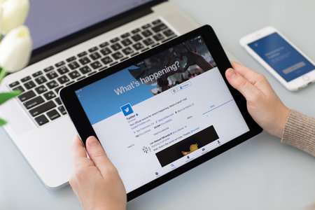 Alushta, Russia - May 26, 2017: Man holding iPad Pro on the table with social networking service Twitter on the screen. iPad Pro was created and developed by the Apple inc.のeditorial素材
