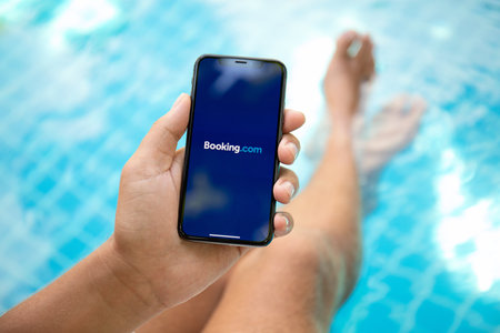 Koh Samui, Thailand - March 22, 2018: Man hand holding iPhone X with application Booking.com online hotel reservations on the screen. iPhone 10 was created and developed by the Apple inc.のeditorial素材