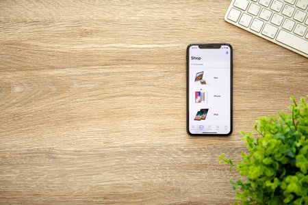 Alushta, Russia - August 22, 2018: iPhone X with application Apple Store in the screen and background wooden desk. iPhone 10 was created and developed by the Apple inc.のeditorial素材