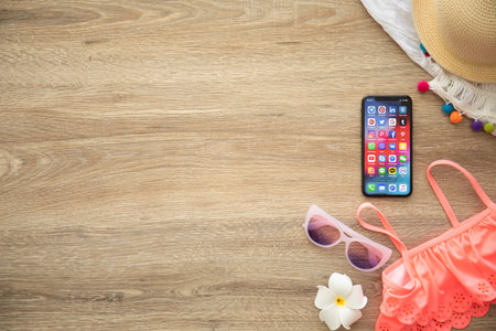 Alushta, Russia - August 26, 2018: iPhone X with social networking Messenger on the screen and background wooden desk. iPhone 10 was created and developed by the Apple inc.のeditorial素材
