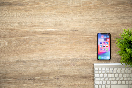 Alushta, Russia - August 26, 2018: iPhone X with social networking Messenger on the screen and background wooden desk. iPhone 10 was created and developed by the Apple inc.のeditorial素材