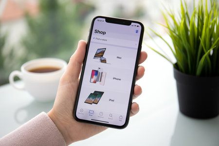 Alushta, Russia - September 24, 2018: Woman hand holding iPhone X with application Apple Store in the screen. iPhone 10 was created and developed by the Apple inc.のeditorial素材