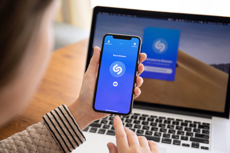 Alushta, Russia - September 26, 2018: Woman hand holding iPhone X with music service Shazam on the...