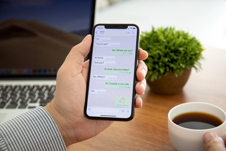 Alushta, Russia - October 8, 2018: Woman holding iPhone X with social networking service WhatsApp on the screen. iPhone 10 was created and developed by the Apple inc.