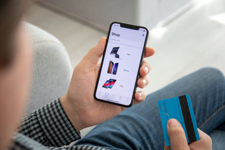 Alushta, Russia - October 9, 2018: Man hand holding iPhone X with application Apple Store in the screen. iPhone 10 was created and developed by the Apple inc.のeditorial素材