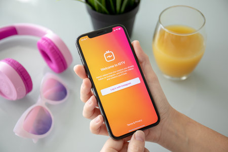 Alushta, Russia - July 27, 2018: Woman hand holding iPhone X with social networking service IGTV Instagram on the screen. iPhone ten was created and developed by the Apple inc.のeditorial素材