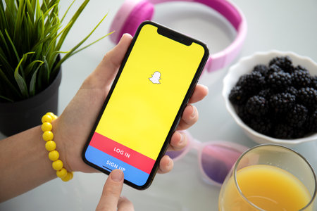 Alushta, Russia - July 27, 2018: Woman holding iPhone with social networking service Snapchat on the screen. iPhone X was created and developed by the Apple inc.のeditorial素材