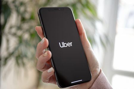 Anapa, Russia - February 20, 2019: woman hand holding iPhone X with application Taxi Uber on the...