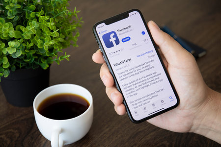 Alushta, Russia - July 30, 2018: Men holding iPhone X with social networking service Facebook on the screen. iPhone ten was created and developed by the Apple inc.のeditorial素材