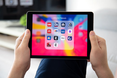 Anapa, Russia - March 26, 2019: Man hand holding iPad Pro with popular news applications on the screen. iPad Pro is created and developed by the Apple inc.のeditorial素材