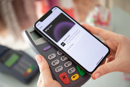 Anapa, Russia - August 10, 2019: Woman hand holding iPhone X with Apple Pay Cash on the screen and pay pass online terminal. iPhone was created and developed by the Apple inc.のeditorial素材