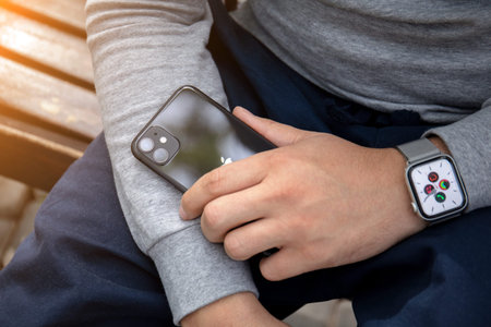 Anapa, Russia - September 26, 2019: Man hand with Apple Watch Series 5 holding iPhone 11. iPhone and...