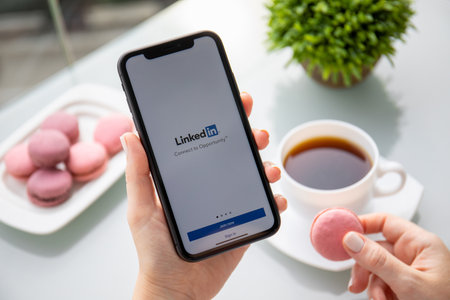 Foto de Anapa, Russia - October 5, 2019: Woman hand holding iPhone 11 with app LinkedIn in the screen. iPhone was created and developed by the Apple inc. - Imagen libre de derechos