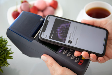 Anapa, Russia - October 1 2019: Woman hand holding iPhone 11 with Apple Pay on the screen and pay...